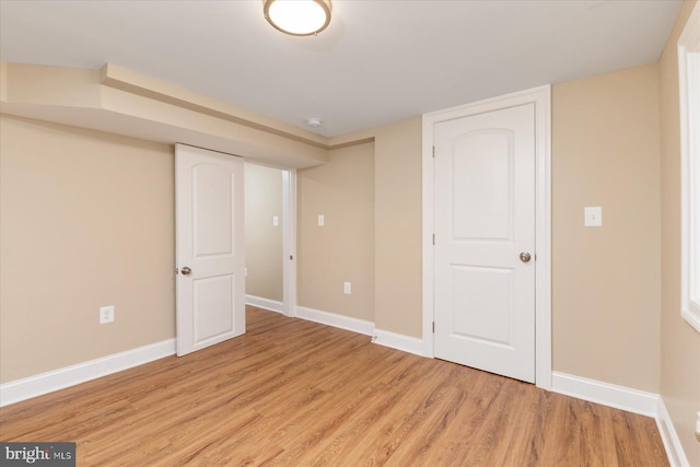 finished below grade area with baseboards and light wood-style floors