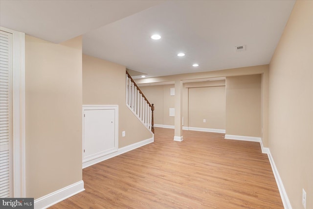 finished below grade area featuring visible vents, stairs, baseboards, recessed lighting, and light wood finished floors