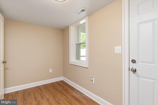 spare room featuring baseboards, light wood finished floors, and visible vents