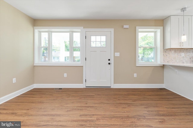 entryway featuring baseboards, light wood finished floors, and visible vents