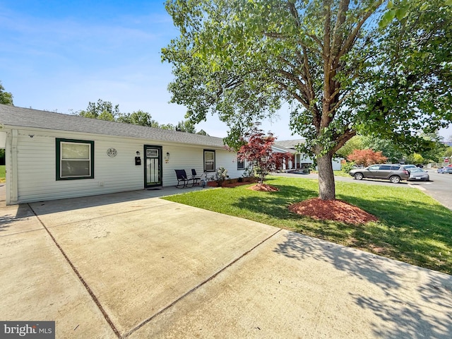 ranch-style house featuring a front yard and concrete driveway