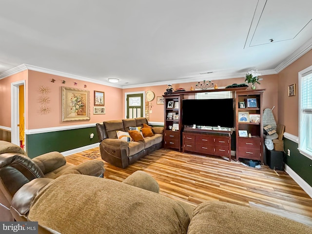 living room with baseboards, ornamental molding, attic access, and light wood-style flooring