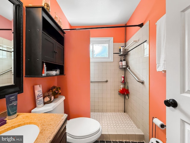 bathroom with vanity, a tile shower, and toilet