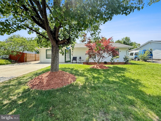 view of front of home with fence, a front yard, and concrete driveway