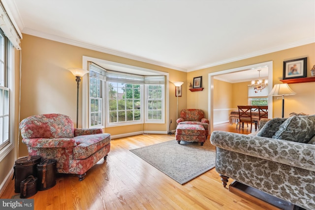 living room with baseboards, a notable chandelier, ornamental molding, and wood finished floors