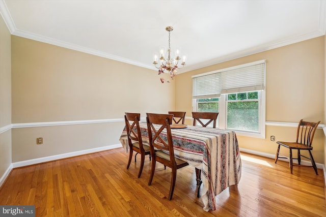 dining space featuring crown molding, baseboards, wood finished floors, and a chandelier