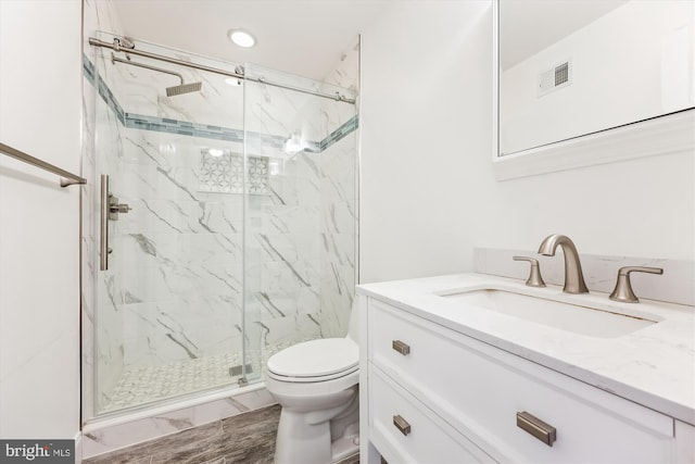 full bath with visible vents, vanity, toilet, a marble finish shower, and recessed lighting
