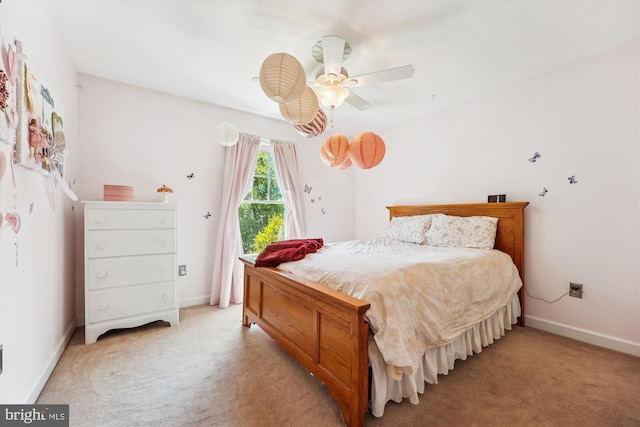 bedroom with baseboards, a ceiling fan, and light colored carpet