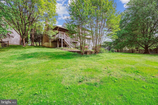view of yard featuring fence, stairway, and a deck