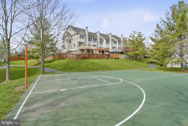 view of basketball court with a lawn, community basketball court, and fence