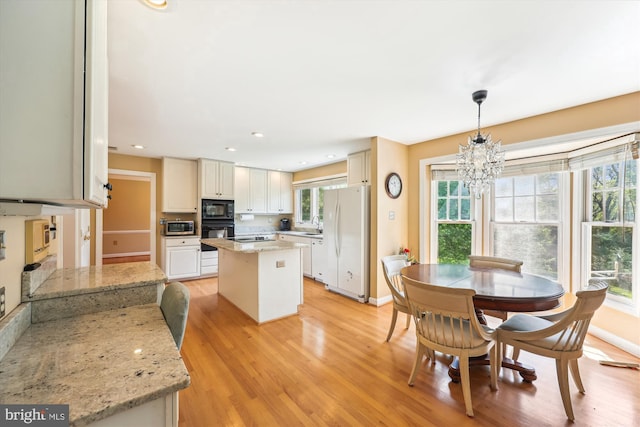 dining room featuring an inviting chandelier, recessed lighting, baseboards, and light wood-type flooring