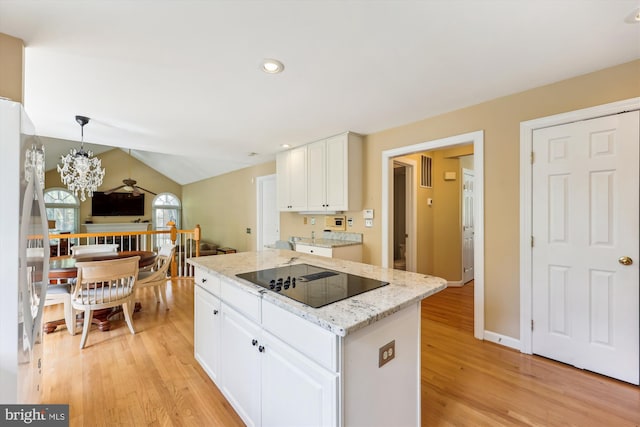 kitchen with white cabinetry, stainless steel refrigerator, black electric stovetop, and light wood-style floors