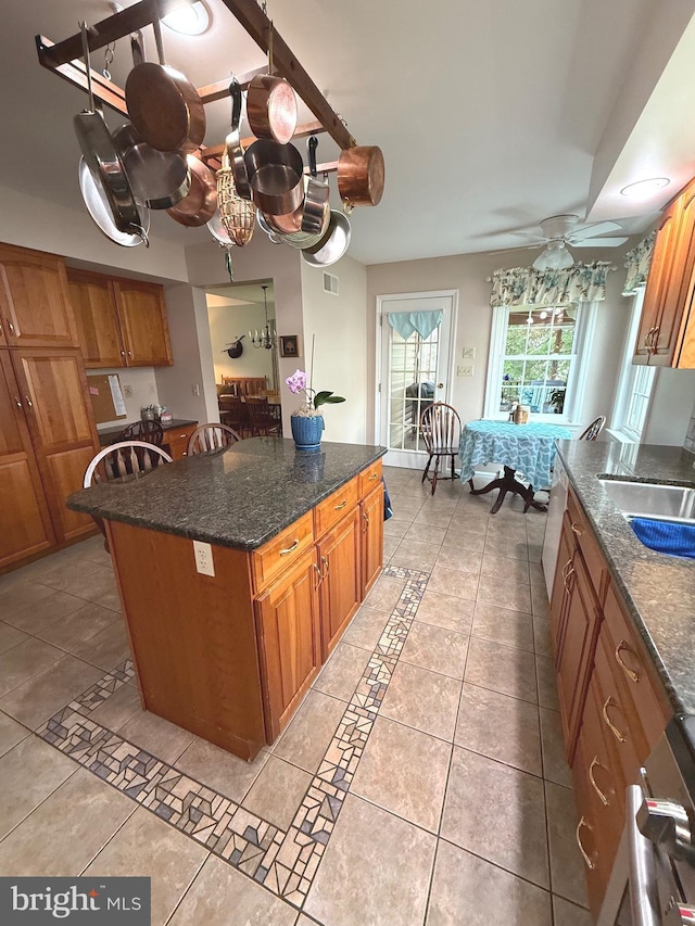902 Hedgewyck Ln, Elizabethtown, PA 17022 - kitchen featuring brown cabinetry, a sink, a center island, light tile patterned floors, and dark stone counters