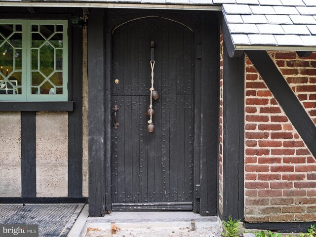 view of exterior entry with brick siding