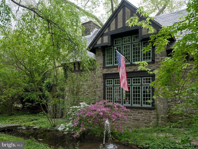 view of side of property featuring stone siding and a chimney
