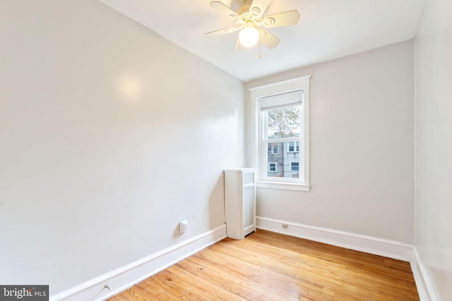 empty room featuring baseboards, light wood-type flooring, and ceiling fan