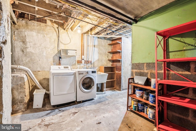 unfinished below grade area with washer and clothes dryer and a sink