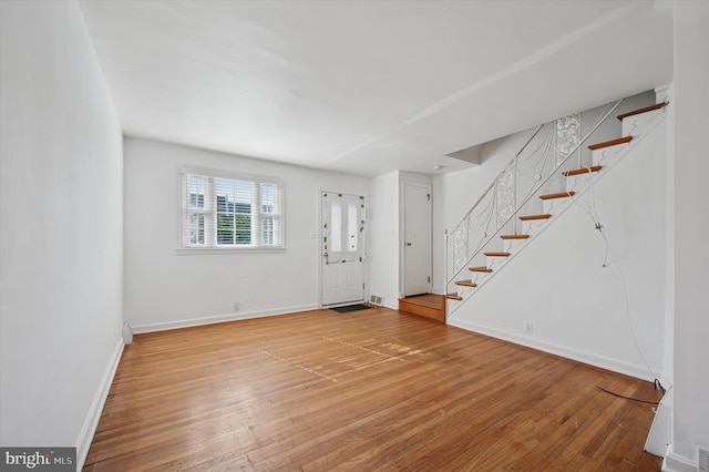 entryway with stairs, baseboards, and hardwood / wood-style floors