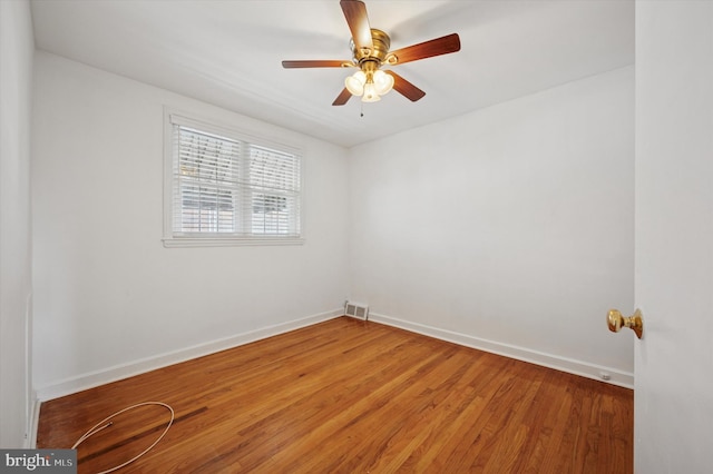 spare room featuring baseboards, ceiling fan, light wood finished floors, and visible vents