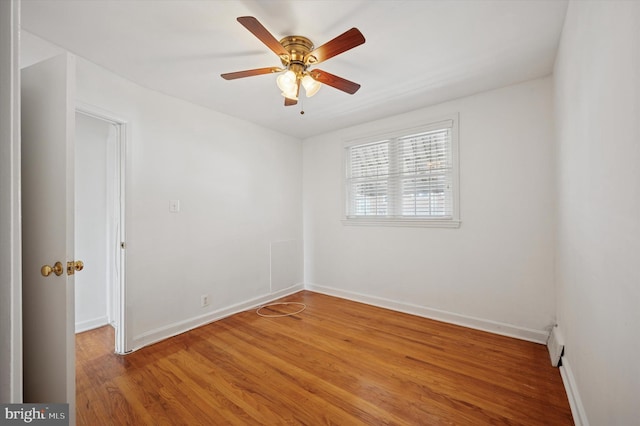 spare room featuring baseboards, a ceiling fan, and light wood finished floors