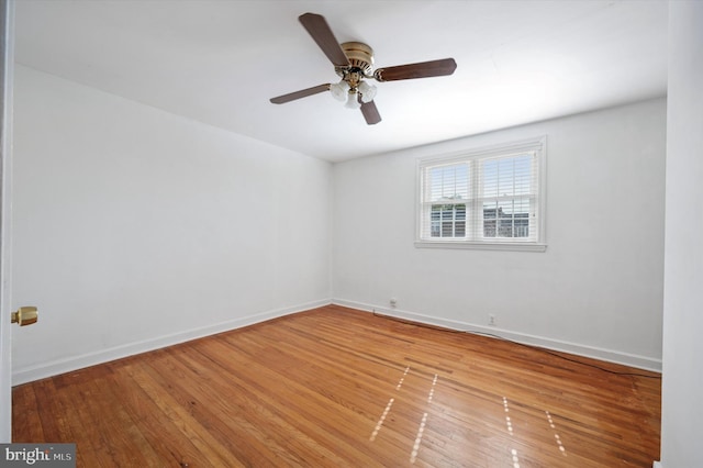 empty room featuring baseboards, a ceiling fan, and wood finished floors