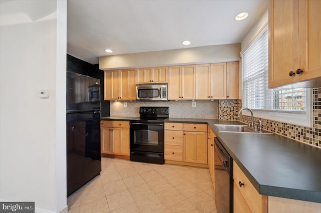 kitchen with decorative backsplash, light brown cabinetry, dark countertops, a sink, and black appliances