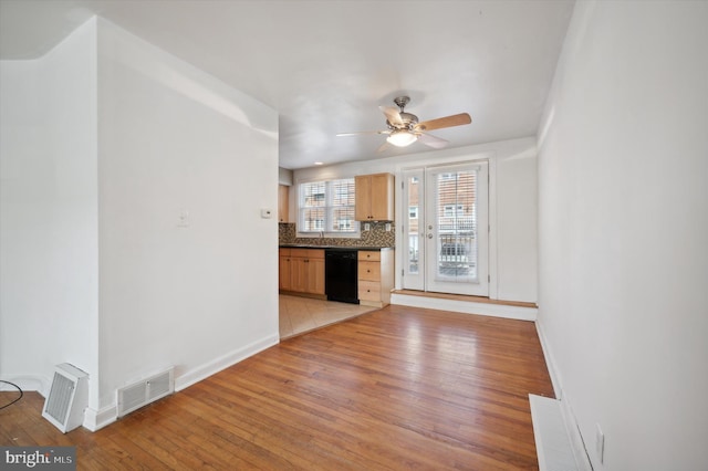 unfurnished living room featuring baseboards, ceiling fan, light wood finished floors, and visible vents