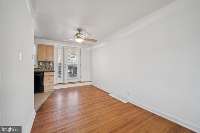 unfurnished living room featuring baseboards, light wood-style flooring, and ceiling fan