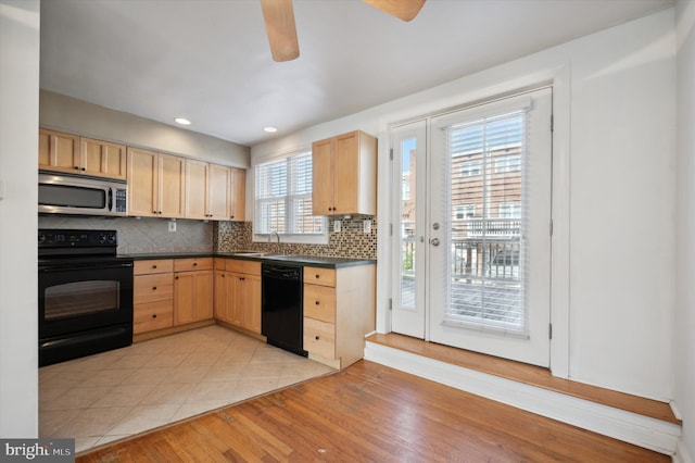 kitchen with dark countertops, light brown cabinets, and black appliances