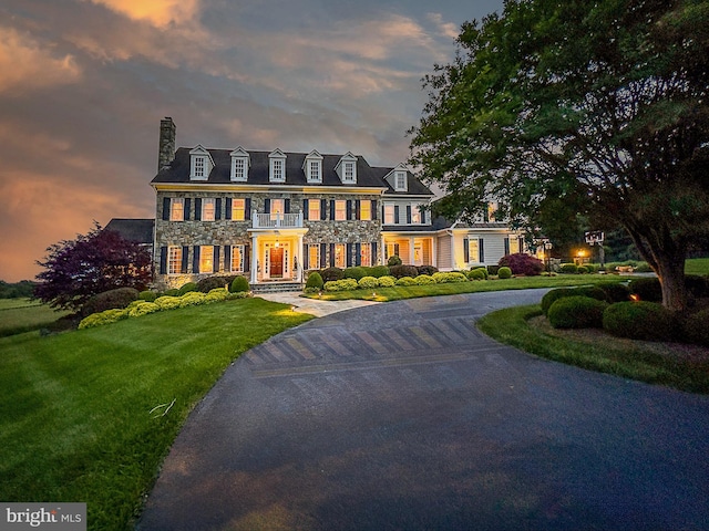 19326 Airwell Ct, Purcellville, VA 20132 - colonial house featuring curved driveway, a front lawn, stone siding, and a chimney