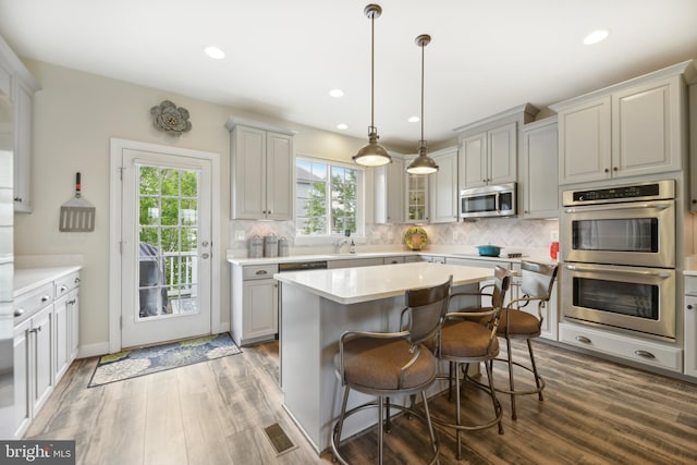 10723 Caledonia Meadow Dr, Manassas, VA 20112 - kitchen featuring stainless steel appliances, wood finished floors, light countertops, decorative backsplash, and recessed lighting