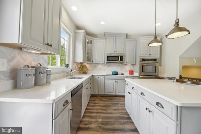 10723 Caledonia Meadow Dr, Manassas, VA 20112 - kitchen with appliances with stainless steel finishes, a sink, backsplash, light countertops, and pendant lighting