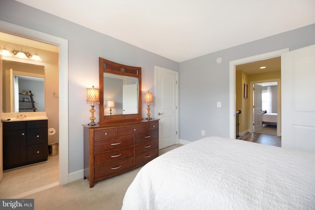 10723 Caledonia Meadow Dr, Manassas, VA 20112 - bedroom with baseboards, light carpet, ensuite bathroom, and a sink