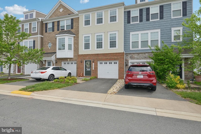 10723 Caledonia Meadow Dr, Manassas, VA 20112 - townhome / multi-family property featuring driveway, an attached garage, and brick siding