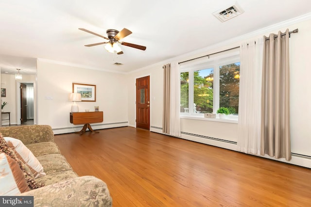 living area with wood finished floors, a ceiling fan, visible vents, a baseboard radiator, and ornamental molding