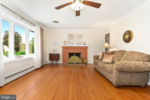 living room featuring ornamental molding, a ceiling fan, baseboard heating, and wood finished floors