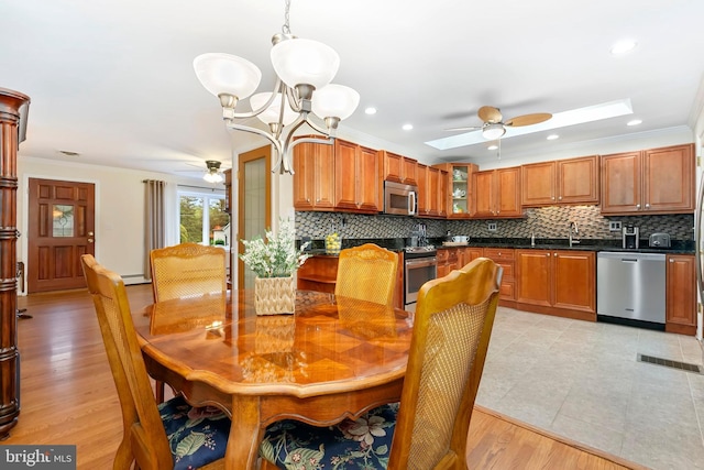 dining area featuring ornamental molding, ceiling fan with notable chandelier, light tile patterned floors, and visible vents
