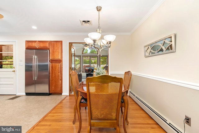 dining space with a baseboard heating unit, crown molding, a chandelier, and visible vents
