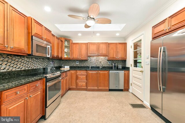 kitchen featuring a sink, a skylight, brown cabinets, and appliances with stainless steel finishes