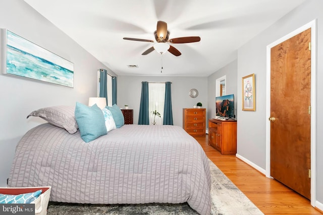 bedroom with ceiling fan, baseboards, light wood-type flooring, and visible vents