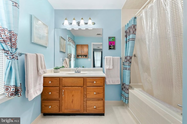 full bath with vanity, visible vents, tile patterned flooring, tiled shower / bath, and baseboards