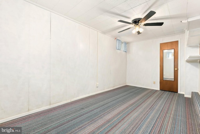 spare room featuring ceiling fan, carpet floors, and baseboards