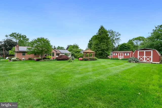 view of yard with a gazebo, an outbuilding, and a storage shed