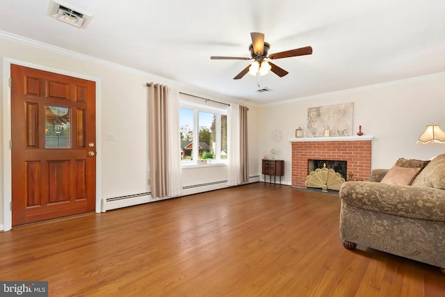 living room with crown molding, visible vents, ceiling fan, and wood finished floors