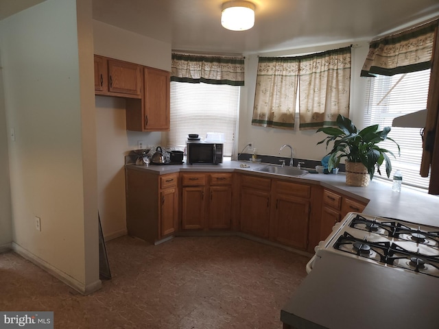 5737 N Park Ave, Philadelphia, PA 19141 - kitchen with black microwave, brown cabinets, baseboards, and a sink