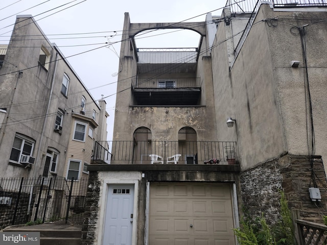 5737 N Park Ave, Philadelphia, PA 19141 - view of front facade featuring stone siding, fence, a garage, and a balcony