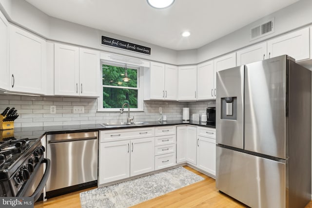 6724 Passageway Pl, Burke, VA 22015 - kitchen featuring appliances with stainless steel finishes, a sink, dark countertops, white cabinetry, and recessed lighting