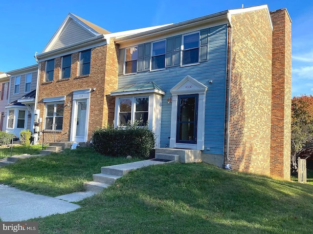 multi unit property featuring a chimney, a front yard, and entry steps