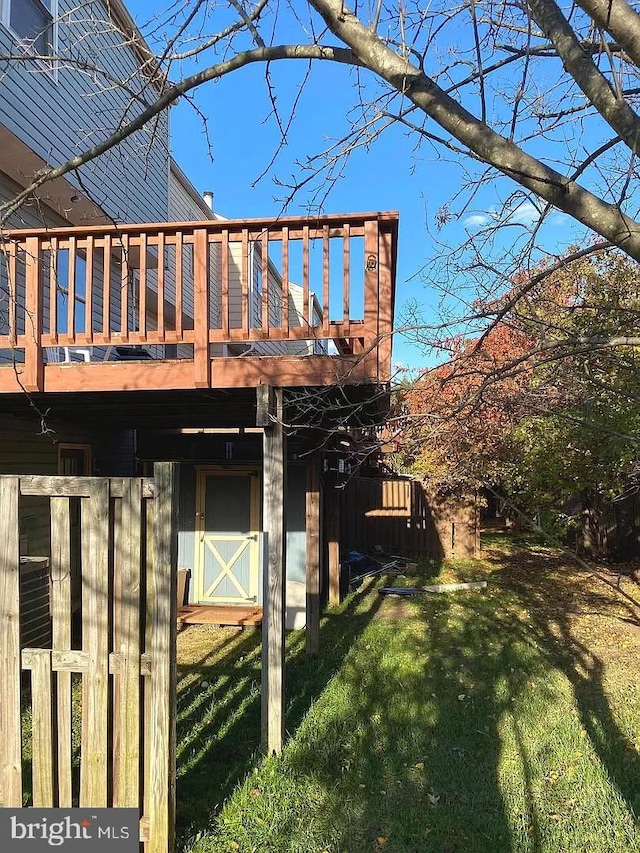 view of property exterior featuring a lawn and a wooden deck