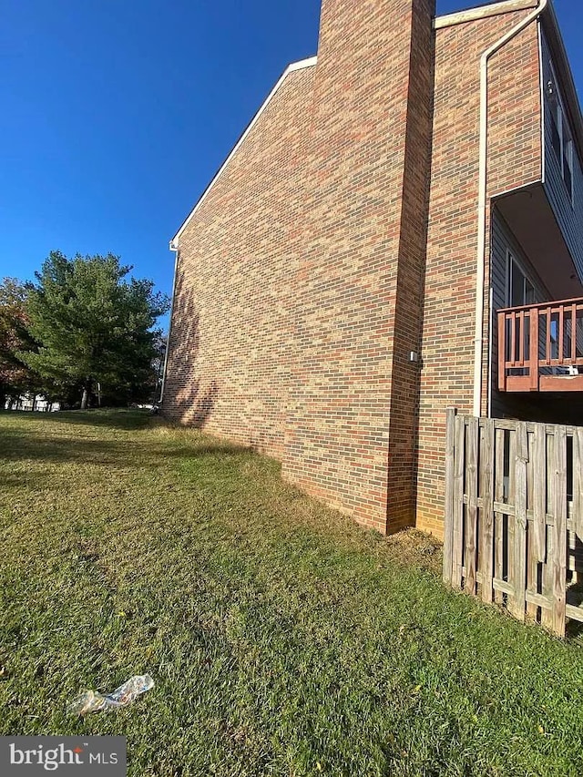 view of home's exterior featuring a yard, fence, and a chimney
